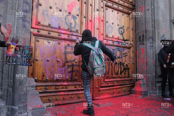 Encapuchadas hacen pintas en fachada de Palacio Nacional
