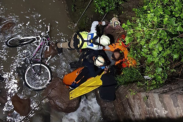 En medio de la tormenta, mujer en bicicleta cae a una barranca