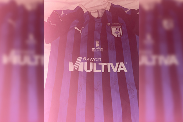 Niño del Querétaro ayuda a aficionada del Atlas dándole su camiseta autografiada