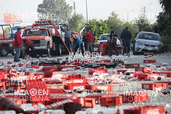 Botellas rotas cubren el asfalto tras choque entre camión refresquero y patrulla